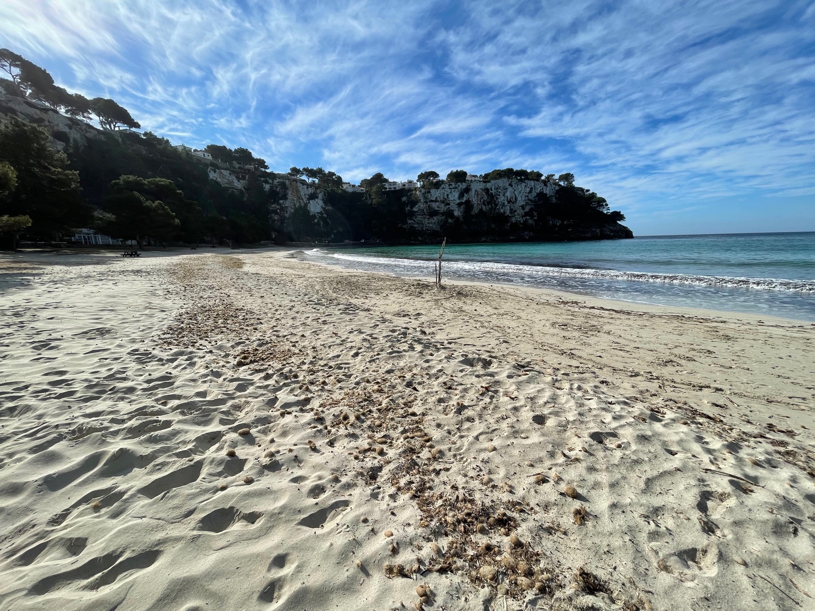 Platja de sorra blanca buida a Cala Galdana en un clar matí d'hivern